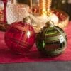 Lot De 12 Boules De Noël (D80 Mm) En Verre Lauri Rouge -Village de Noel 12 boule verre transparent a lignes croisees paillettes 2col ass red green 129047 1687268970
